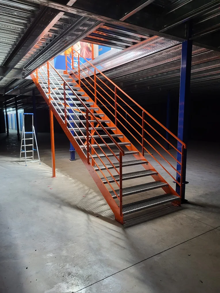 Escalier métallique industriel thermolaqué orange avec marches en caillebotis
